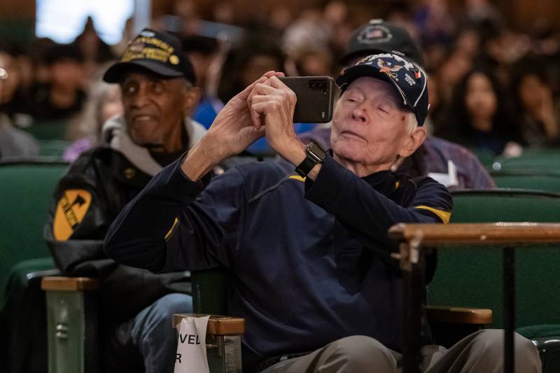 Navy veteran Lloyd Lundberg takes a photo of his fellow veterans during the Veterans Day Assembly at Joliet Central High School on Nov. 7, 2025.