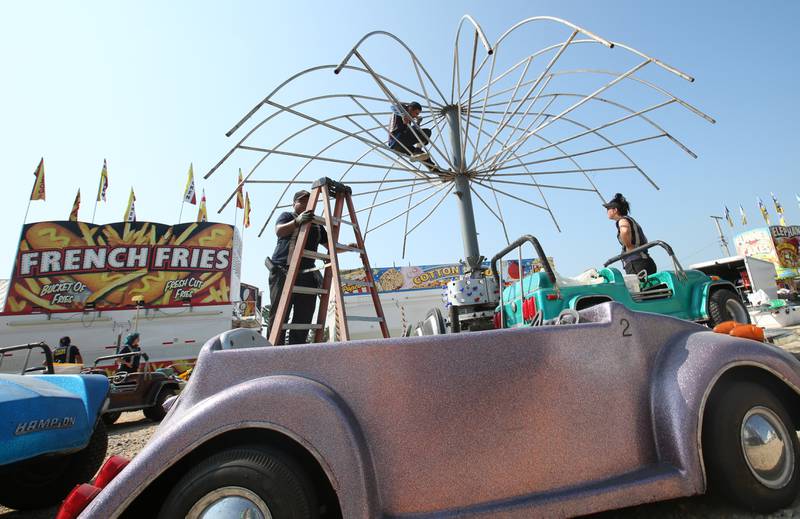 North American Midway Entertainment carnival workers set up a ride for the 168th annual Bureau County Fair on Tuesday, Aug. 22, 2023 in Princeton.