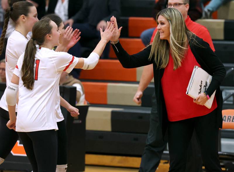 Huntley head coach Karen Naymola high fives her players as they come off the court during a time out Monday, Nov. 11, 2024, in their Class 4A supersectional win over Fremd at DeKalb High School.