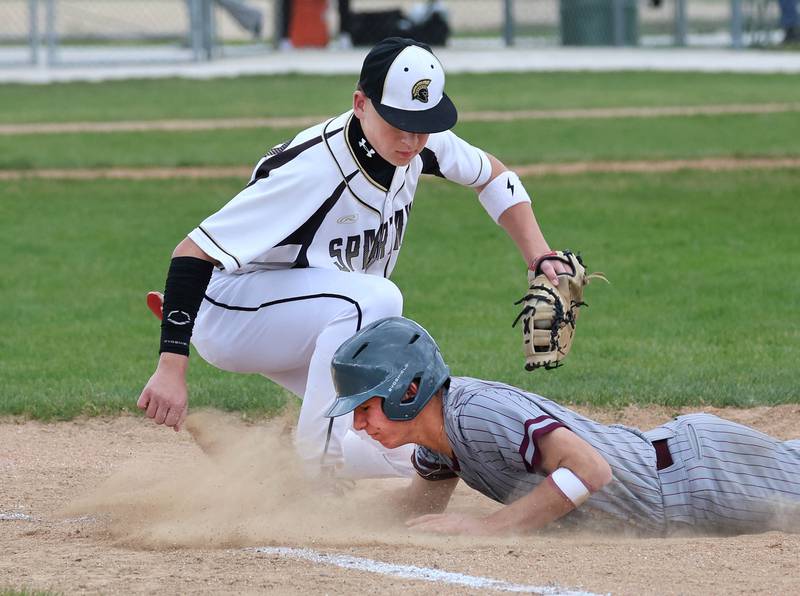 Morris' Brycen Johnson dives back into first just ahead of the tag of Sycamore's Noah Neece Wednesday, May 13, 2026, during their game at the Sycamore Community Sports Complex.