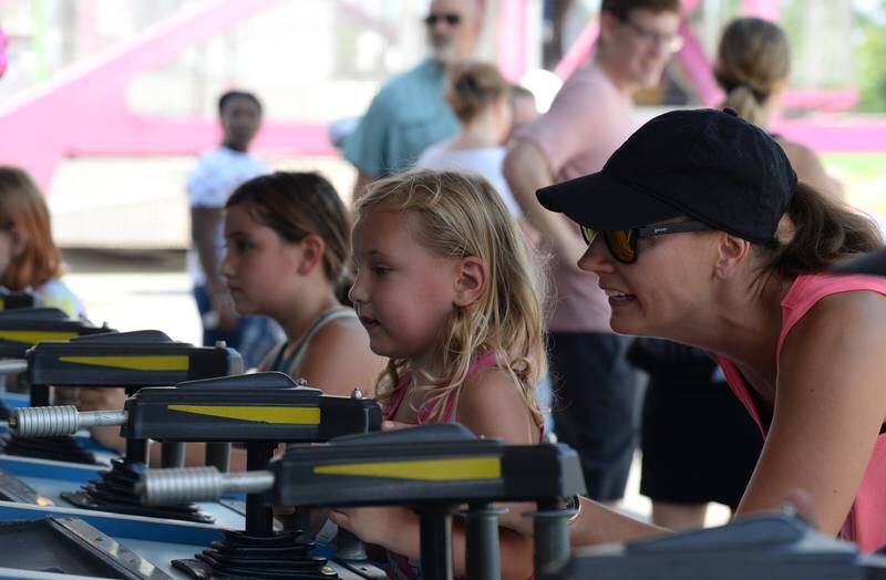 Lindsay Diaz of Oak Park helps her daughter Charlie with the water gun game during the La Grange Summerfest Saturday Aug 6, 2022.