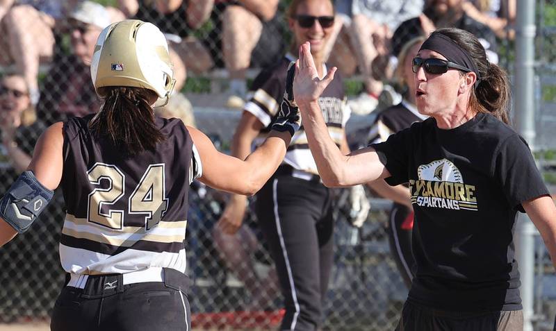 Sycamore head coach Jill Carpenter high fives Kairi Lantz as she heads to home plate after homering during their Class 3A regional championship game against Freeport Friday, May 26, 2023, at Sycamore High School.