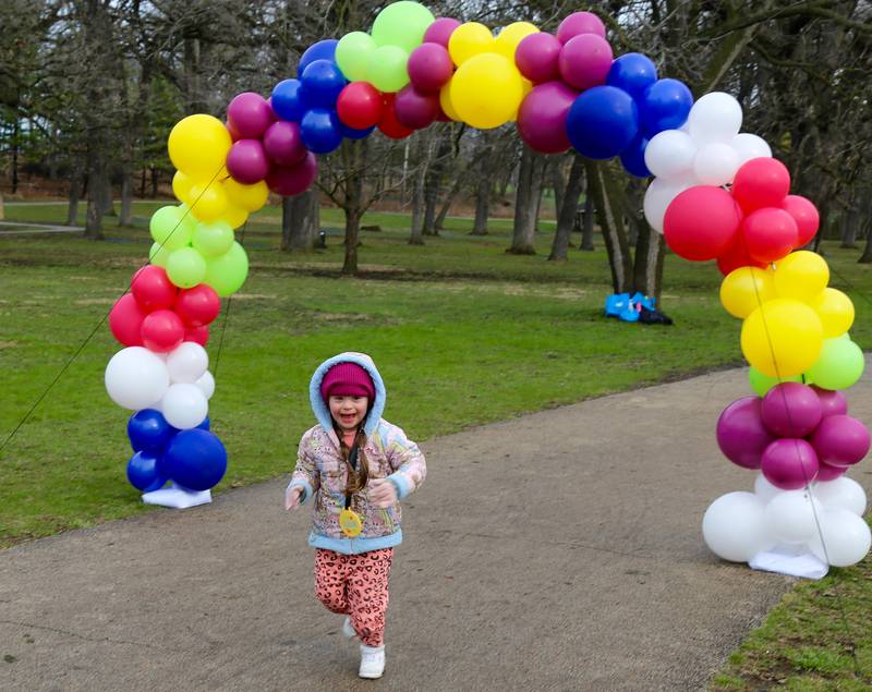Five year old Rylie Racine crosses the finish line at the Color Outside the Line 5K that was held in Geneva on April 5, 2025.