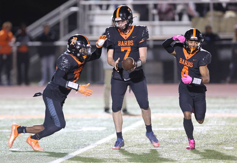 DeKalb's Adrien McVicar hands the ball to Jamari Brown during their game against Naperville Central Friday Oct. 7, 2022, at DeKalb High School.