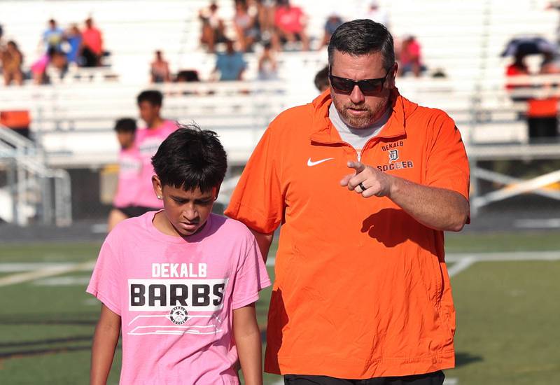 DeKalb boys soccer head coach Patrick Hamilton helps an injured player off the field Monday, July 14, 2025, before a summer boys soccer friendly against Sycamore at DeKalb High School.