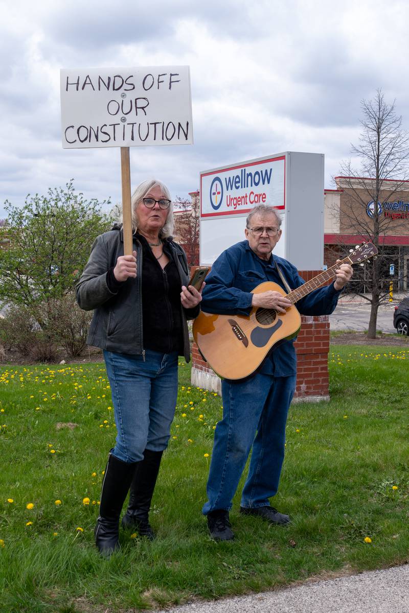 Steve Bruesewitz performs Woody Guthrie’s “This Land Is Your Land" song with Aurora LGTBQ+ Advisory Board member Pauline Spika singing along during the Hands Off protest along Randall Road in South Elgin, IL on Saturday April 19, 2025.  Hundreds of protesters participated in the latest Hands Off protest occurring in the Chicagoland area and the rest of the country.