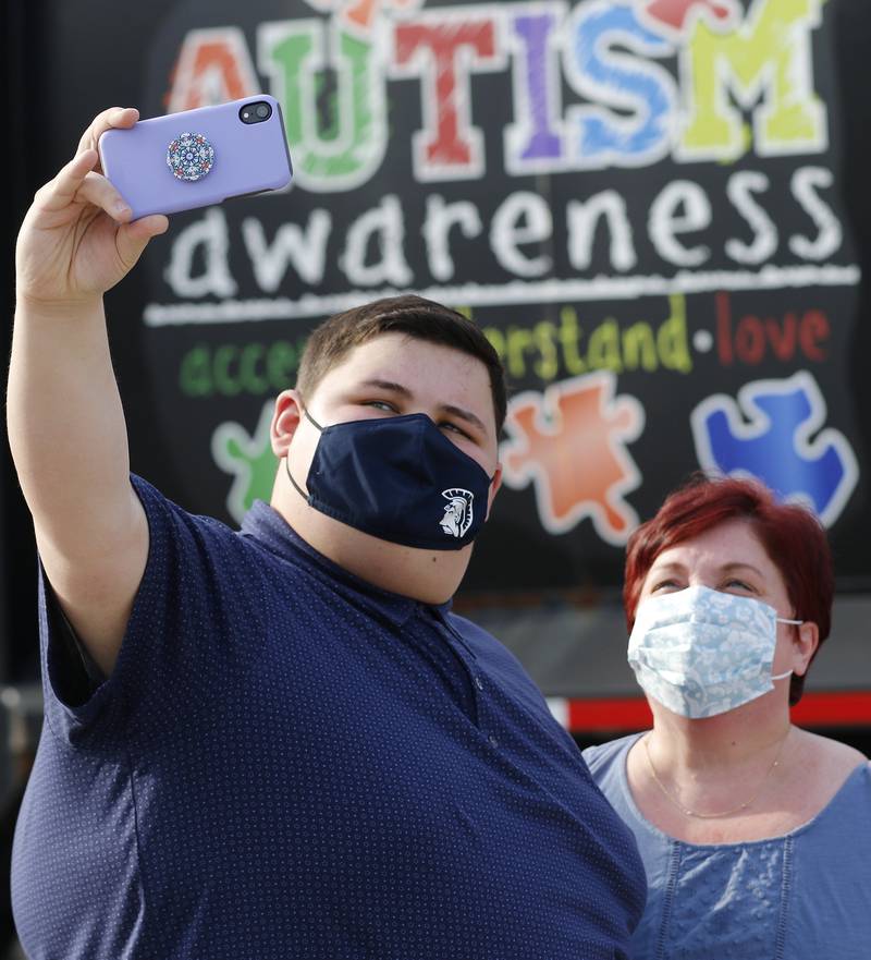 Danny Brezina snaps a selfie with his mom, Missi, with a Flood Brothers waste management truck displaying Autism Awareness messages outside Cary Village Hall prior to delivering an Autism Awareness Proclaimation during a village board meeting on Tuesday, April 6, 2021 in Cary.  This was the third year Brezina, a senior with autism at Cary-Grove High School, was offered the opportunity to deliver the proclamation during a village board meeting in Autism Awareness month.