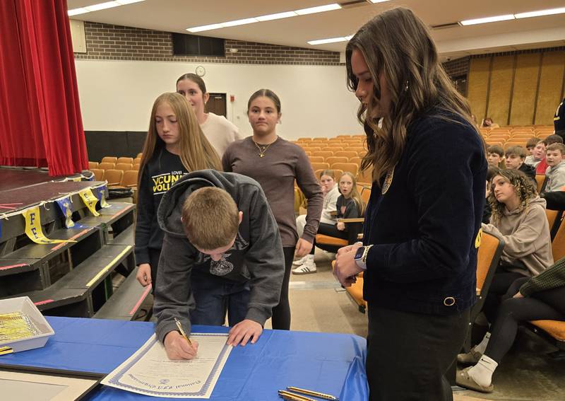 Illinois Association FFA State President Natalie Pratt (right), an Amboy FFA Alumni, oversees the student signing of the middle school Amboy FFA charter Nov. 10, 2025.