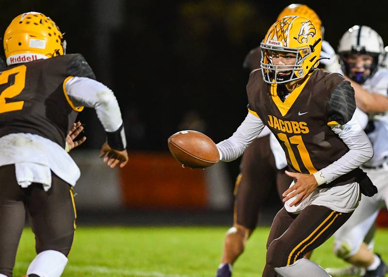 Jacobs quarterback Max Benner hands off to Antonio Brown during their Fox Valley Conference game against Cary Grove on Friday, Oct. 6, 2022 in Algonquin.