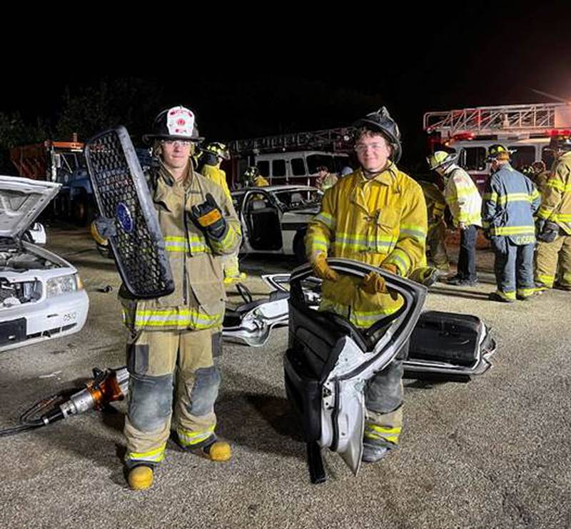 Jake Ftacek (left) and Danny Markun (right) show off the parts of the automobile they helped to disassemble as they learned about extrication in the Joliet Fire Department Citizen Fire Academy.