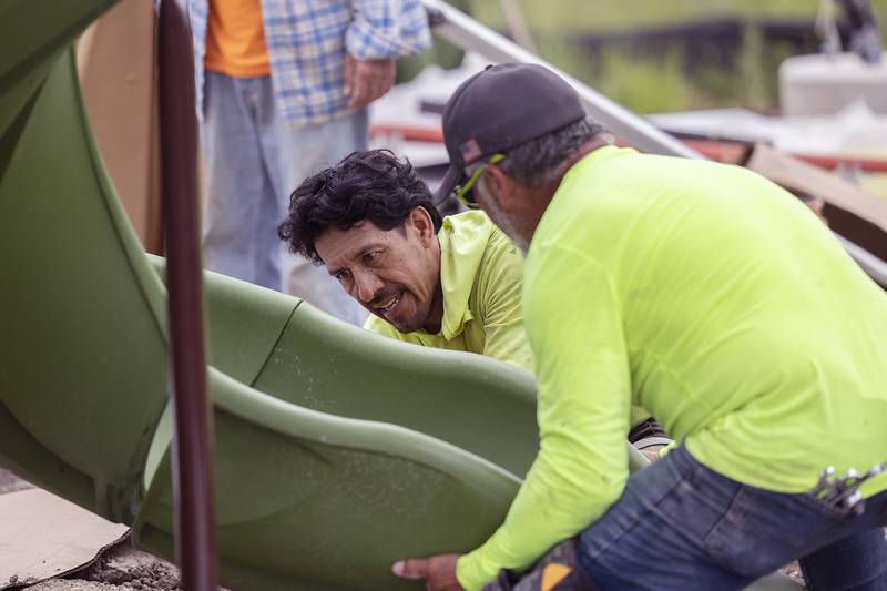 Workers get a slide in place Tuesday, July 8, 2025, at Sterling’s riverfront park. Installation of the equipment is hoped to be complete by the end of the week.