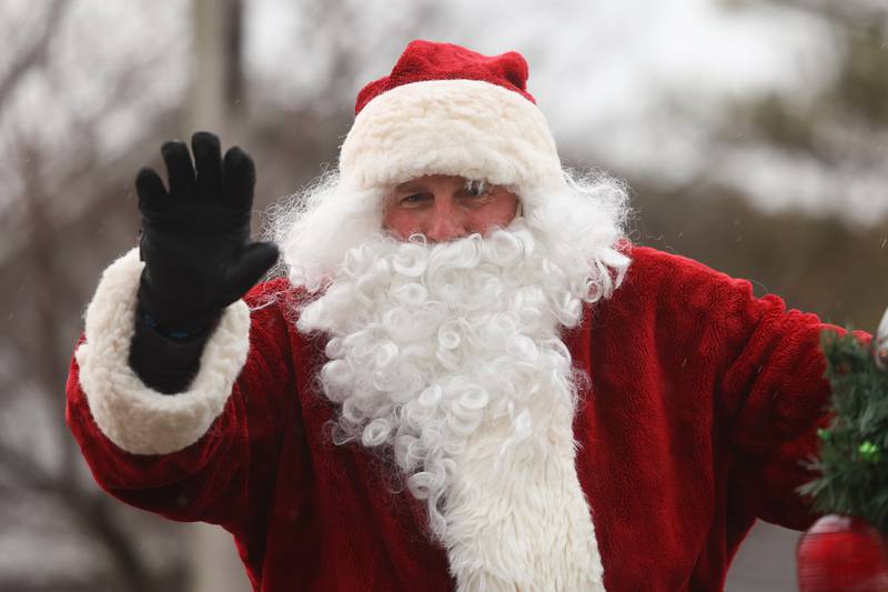 Santa waves to a family as the Joliet police escorts him through Joliet as he heads to the North Pole to get ready for Christmas Eve on Saturday, Dec.16th in Joliet.