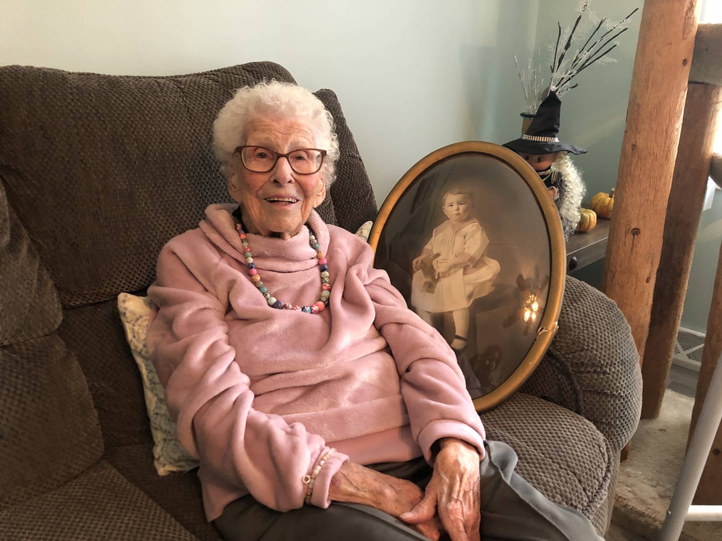 Genevieve "Genny" Hay poses with a portrait taken of her as a child on Saturday, Nov. 5, 2022. Hay, of Lake in the Hills,  was born in 1917.