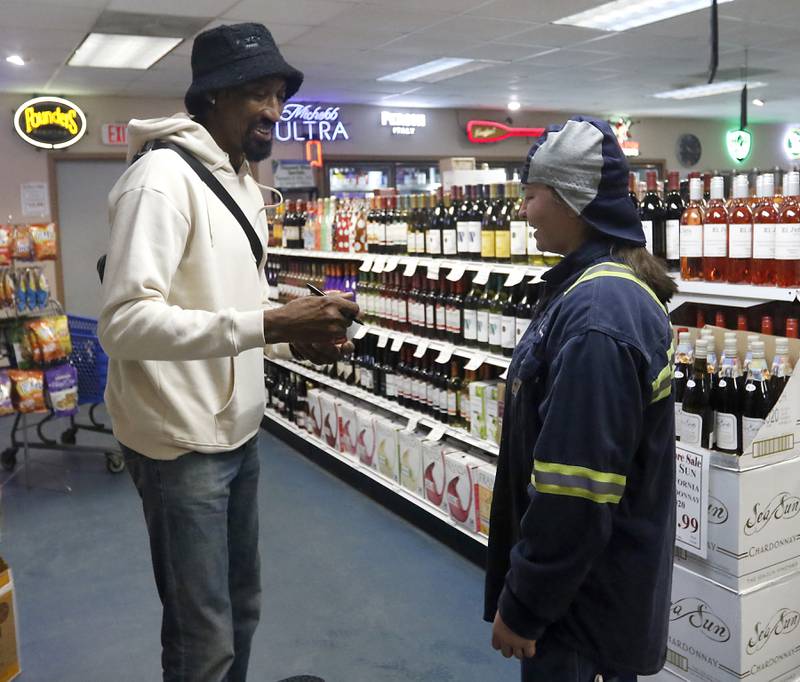Emilie Fratz talks with retired Chicago Bulls star Scottie Pippen as he signs a bottles of his Digits bourbon Thursday, Feb. 9, 2023, at The International House of Wine and Cheese, at 11302 Route 12, in Richmond.