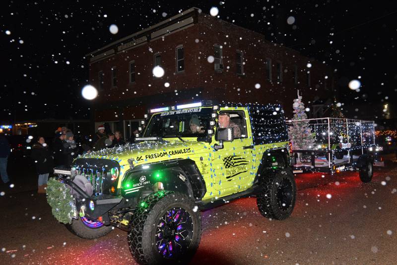 A decorated Jeep follows Hanford Insurance's  snow-making float during the Erie Hometown Holiday Lighted Parade on Saturday, Dec. 2, 2023.