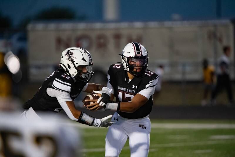Plainfield North's Justus Byrd hands the ball off to Malik Jassim during a game against Joliet West Friday Sept. 20, 2024 at Plainfield North High School