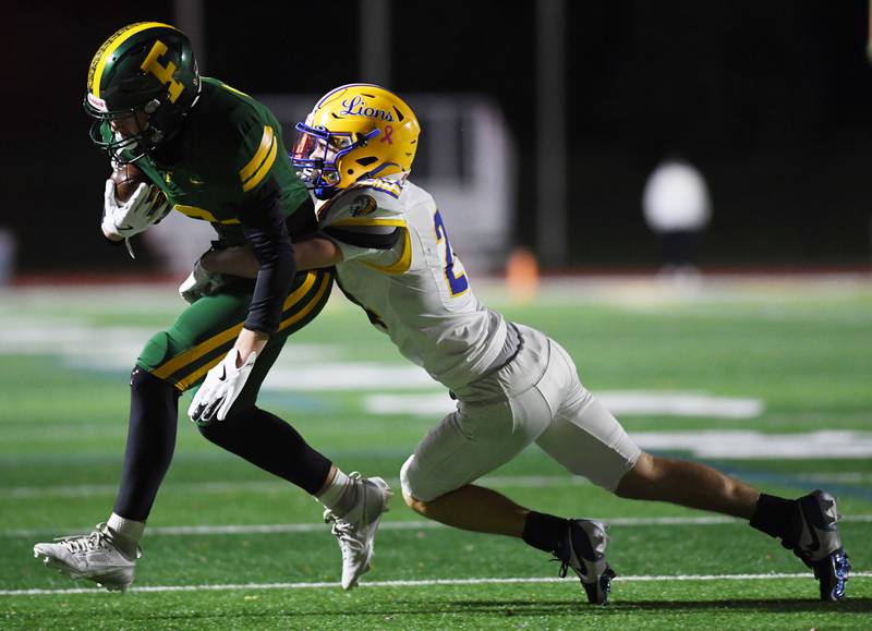Fremd’s Carter MacDonald, left, gets tackled by Lyons Townships’ Ian Collins during a second-round Class 8A football playoff game in Palatine Friday.