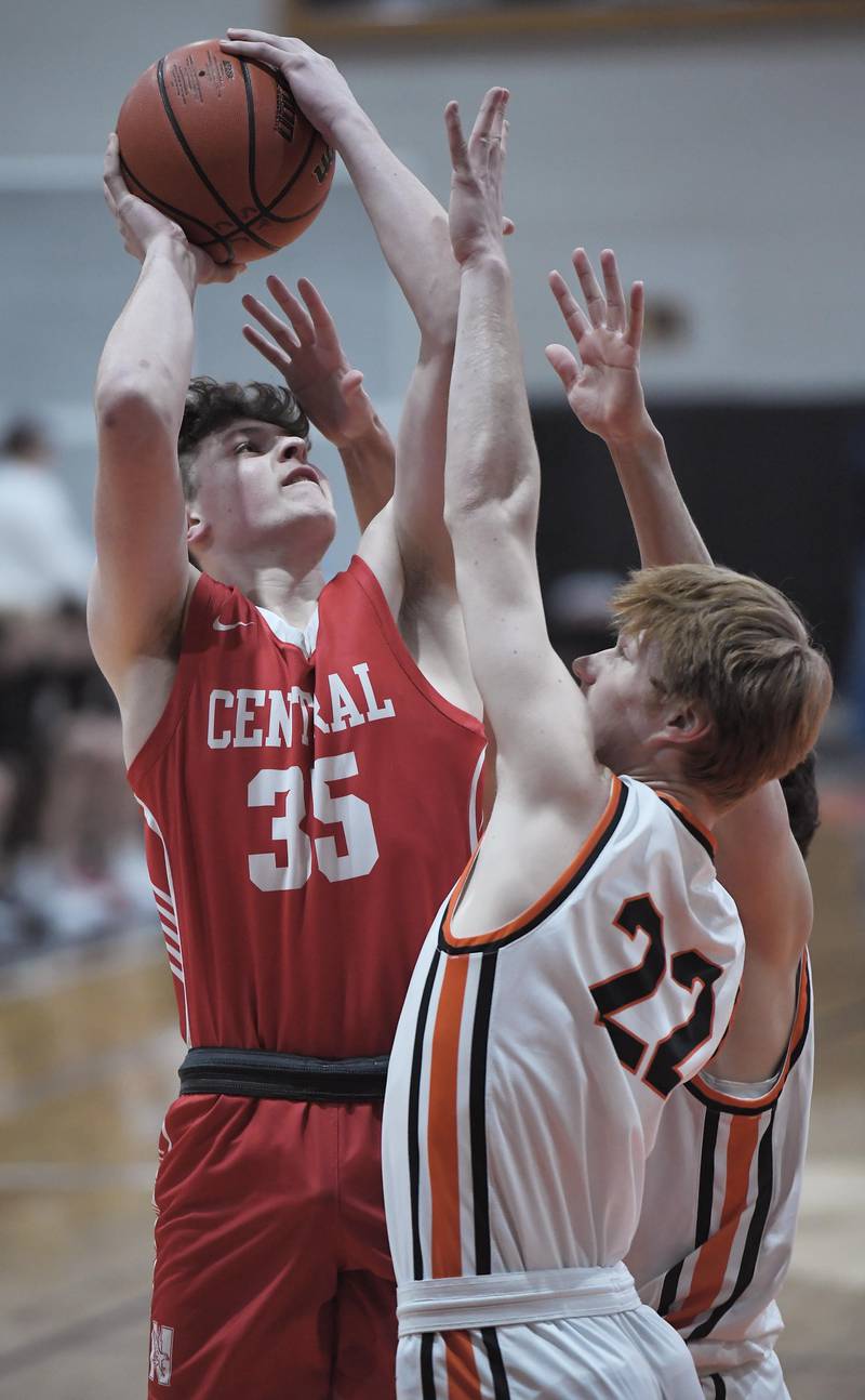 Naperville Central’s Jack First shoots over St. Charles East’s Brad Monkemeyer and Eddie Herrera in a boys basketball game in St. Charles on Wednesday, January 25, 2023.