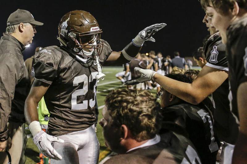 Joliet Catholic's Michael Johnson is congratulated by his teammates after scoring a touchdown during last season's game against Marian Central. Johnson had planned to continue his career at Southwest Missouri State but has enrolled at St. Francis instead.