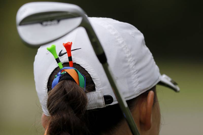 Crystal Lake Central co-op’s Ella Nawracaj wears tees in her hair as she wats to chip onto the 12th green during the Fox Valley Conference Girls Golf Tournament Wednesday, Sept. 24, 2025, at Crystal Woods Golf Club in Woodstock.