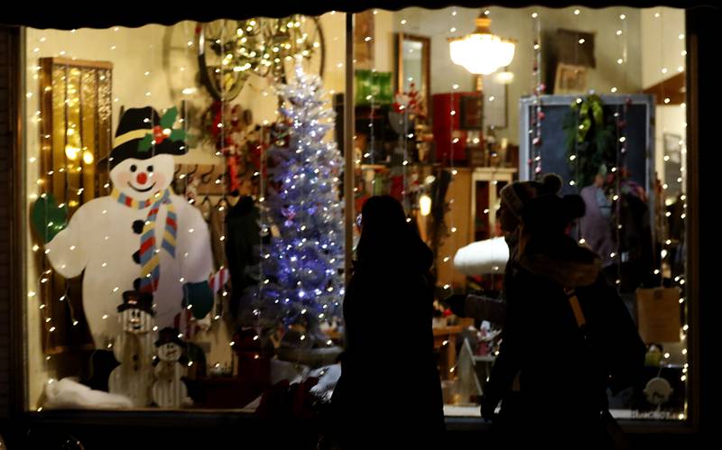 People window shop during the Lighting of the Square Friday, Nov. 29, 2024, in Woodstock. The annual holiday season event featured brass music, caroling, free doughnuts and cider, food trucks, festive selfie stations and shopping.