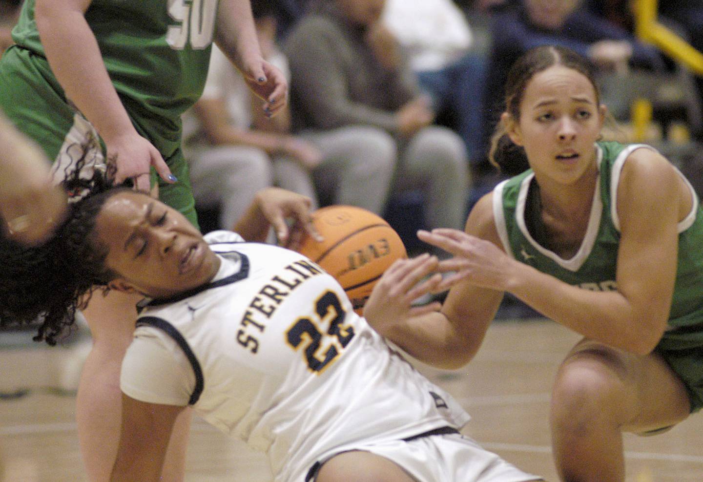 Sterling's Joslyn Green and Geneseo's Maddie Reade fight for a loose ball. Sterling girls basketball hosted Geneseo at Musgrove Fieldhouse in Sterling. The action took place on Thursday, December 11, 2025.