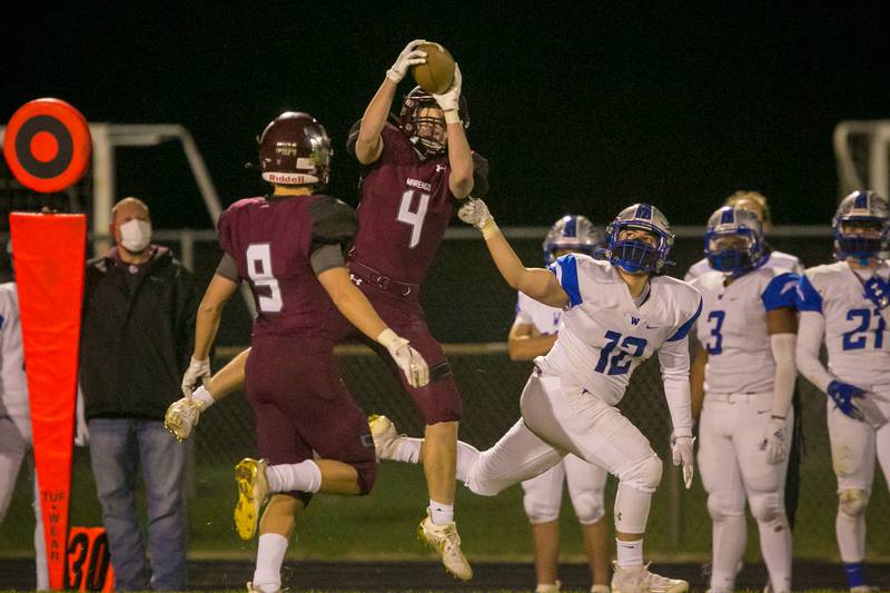 Marengo defensive back Mitch Kunde (4) intercepts a pass intended for Woodstock running back Sam Vidales (12) in the third quarter of the game at Marengo Community High School on Friday, April 9, 2021, in Marengo, Ill. The Indians won, 41-21.