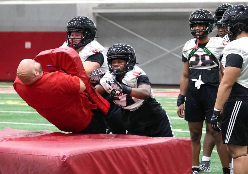 Northern Illinois University defensive tackle Mark Hensley (left) and defensive end Ivan Moore Jr. knock down a coach during a special teams drill Wednesday, July 31, 2024, at practice in the Chessick Practice Center at NIU.