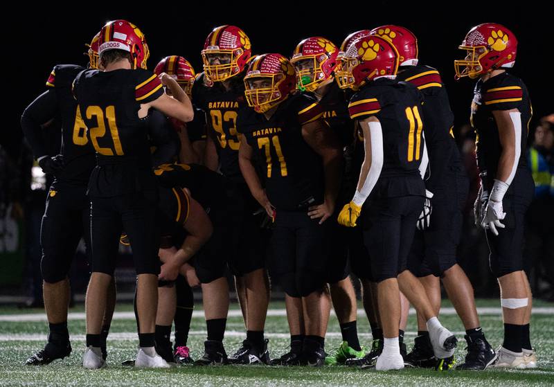 Batavia’s Ryan Boe (21) calls a play in the huddle during a football game against Geneva at Batavia High School on Friday, Oct 7, 2022.