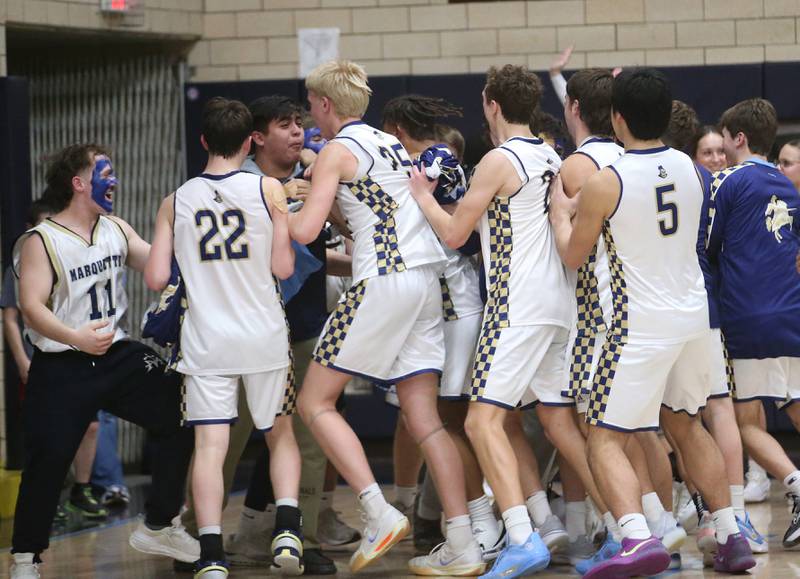 Members of the Marquette boys basketball team celebrate their victory with super fans after defeating Seneca on Friday, Feb. 21, 2025 in Bader Gym at Marquette Academy.