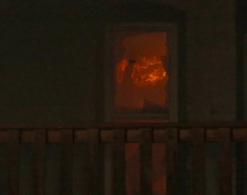 Flames can be seen in an apartment window toward the rear of the building at 708 Illinois Avenue on Friday, Dec. 30, 2022 downtown Mendota.