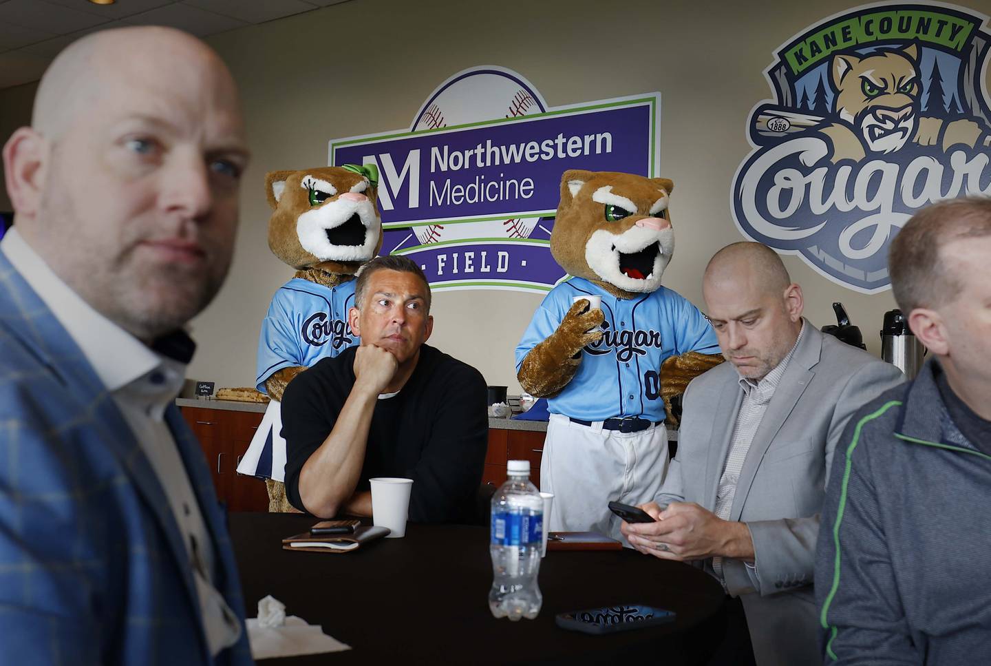 Mascots Ozzie T. Cougar and his sister Annie T. Cougar enjoy some coffee as Rev Entertainment announces they are the new owners of the Kane County Cougars during a press conference Wednesday, April 2, 2025 at Northwestern Medicine Field in Geneva Ill.