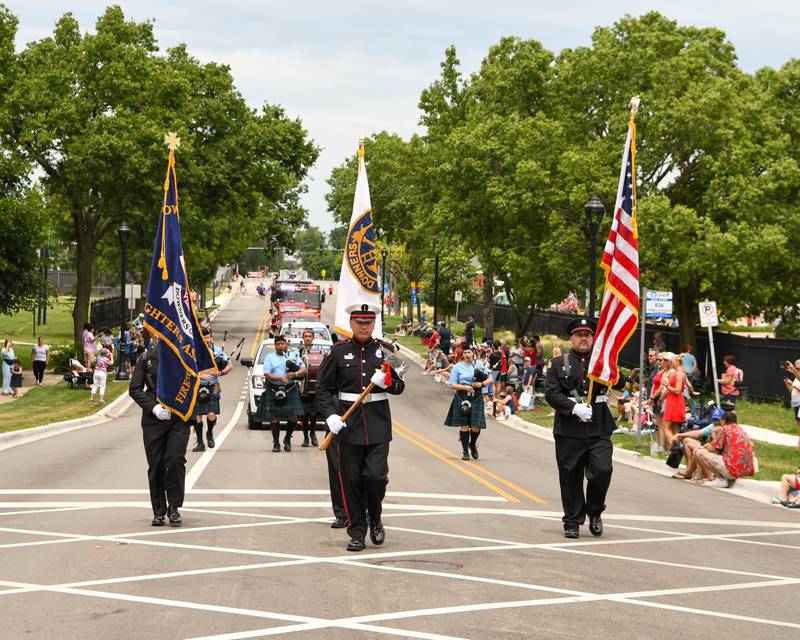 Members of the Downers Grove Fire department present the colors as they march down Main Street in downtown Downers Grove during the Independence Day parade held on Friday July 4, 2025, in Downers Grove.