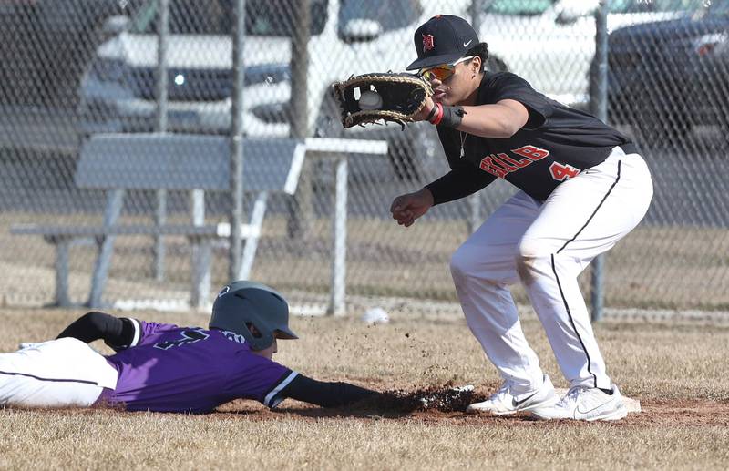 DeKalb’s Maddux Clarence takes the throw on a pickoff attempt as Dixon's Alex Harrison dives back safely during their game Tuesday, March 28, 2023, at DeKalb High School.