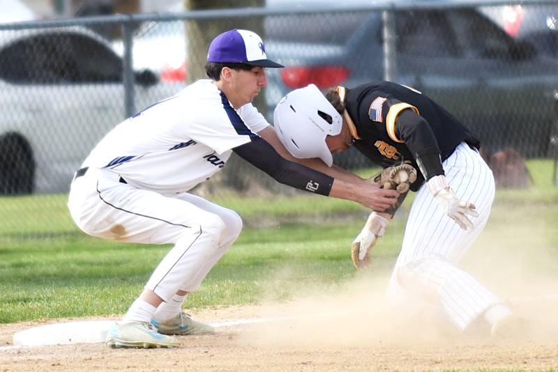 Manteno's Braden Campbell, left, applies a tag on Reed-Custer's Landen Robinson during a game at Manteno Monday, April 14, 2025.