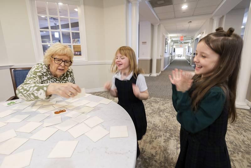 St. Andrew’s first graders Maizie (left) and Khloe celebrate a correct choice by Gloria Noack Thursday, Jan. 30, 2025, at Morningside of Sterling. The school visited the facility in celebration of Catholic Schools Week.