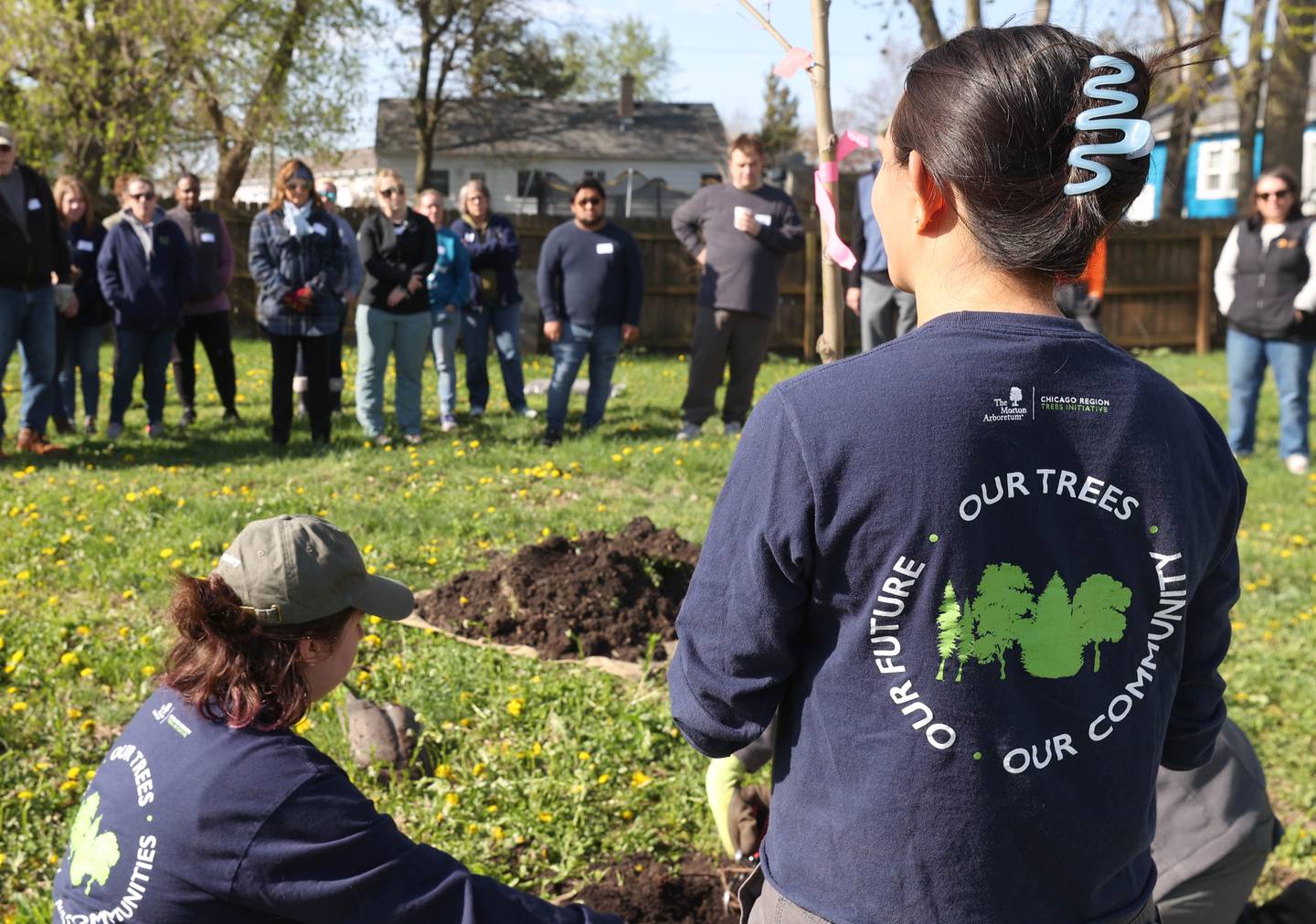 Employees of the Morton Arboretum instruct volunteers on the proper way to plant trees Tuesday, April 21, 2026, during the planting event at Elder Care Services in DeKalb. Several trees were planted by volunteers at the location to kick off the DeKalb Township’s 250 Trees for Tomorrow initiative.