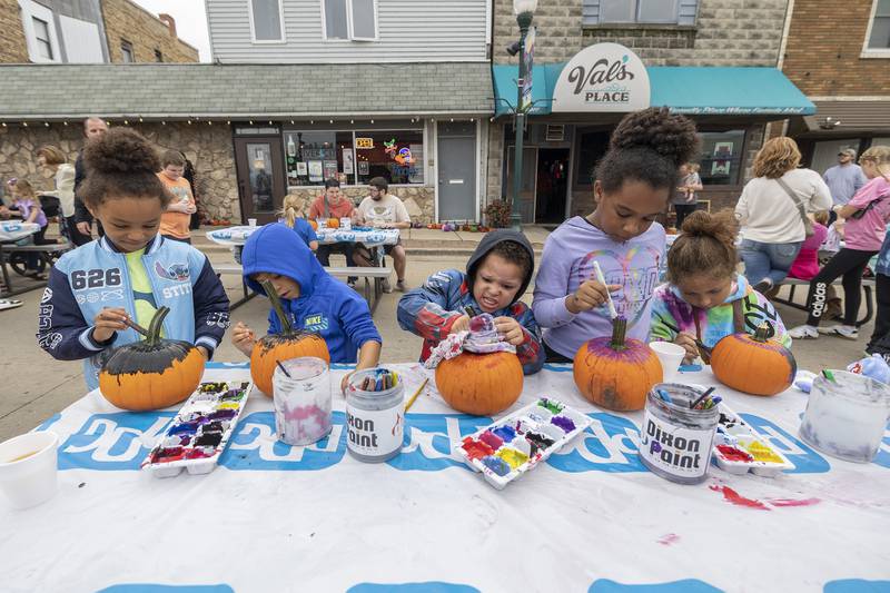 Members of the Dodd-Westmorland family work on pumpkin painting Saturday, Oct. 18, 2025, at Dixon’s Scarecrow Fest. An estimated 800 pumpkins were offered up to budding artists at the festival.