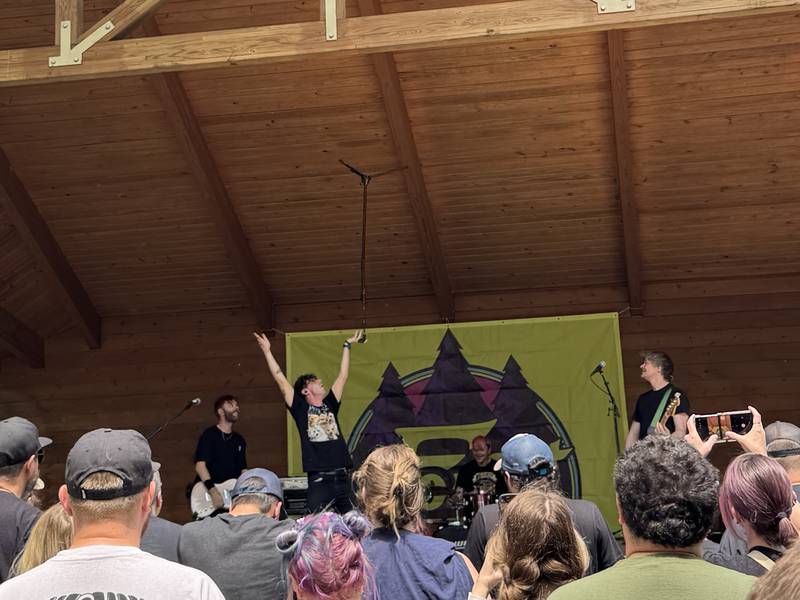 The lead singer of Pet Needs balances the microphone stand on his fingertips during their set at fForest Fest 2025 on Saturday, June 7, 2025.