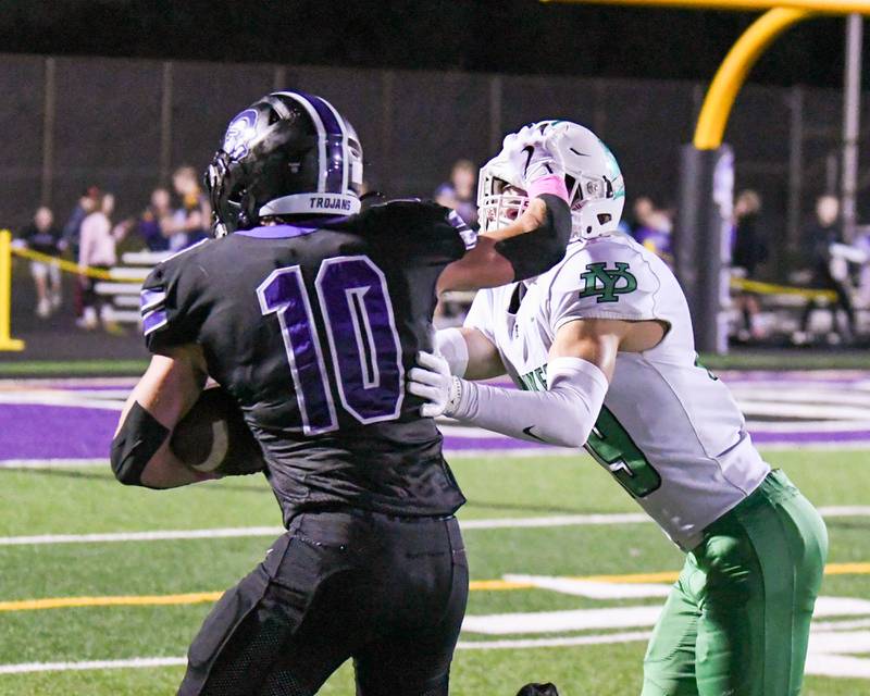 York's Caden Bialecki, right, gets stiffed armed before bringing down Downers Grove North's Oliver Thulin (10) as Oliver catches a long pass for a first down during the game on Friday Oct. 10, 2025, held at Downers Grove North High School.