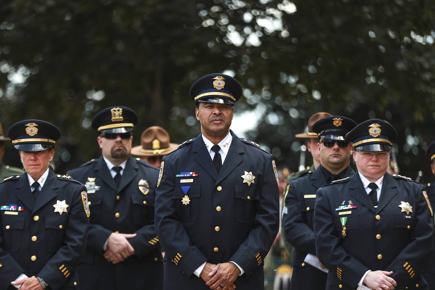 Deputy Police Chief Robert Brown (center) and members of the Joliet Police Department watch on during the closing benediction on Thursday, May 20, 2021, at the Will County Court House in Joliet, Ill. The Police Chief's Association of Will County hosted the 40th Annual Law Enforcement Memorial.