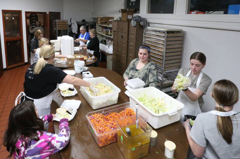 Volunteers help prepare carryouts during the 24th annual Lighted Way Spaghetti dinner on Monday, March 27, 2023 at Uptown in La Salle.