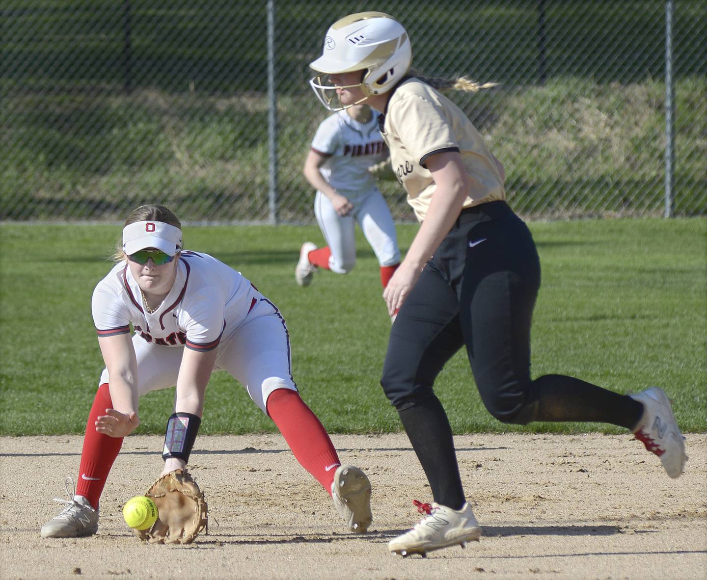 Ottawa’s Piper Lewis fields a ground ball at shortstop as Sycamore’s Riley Schuller looks to advance to third Wednesday at Ottawa.