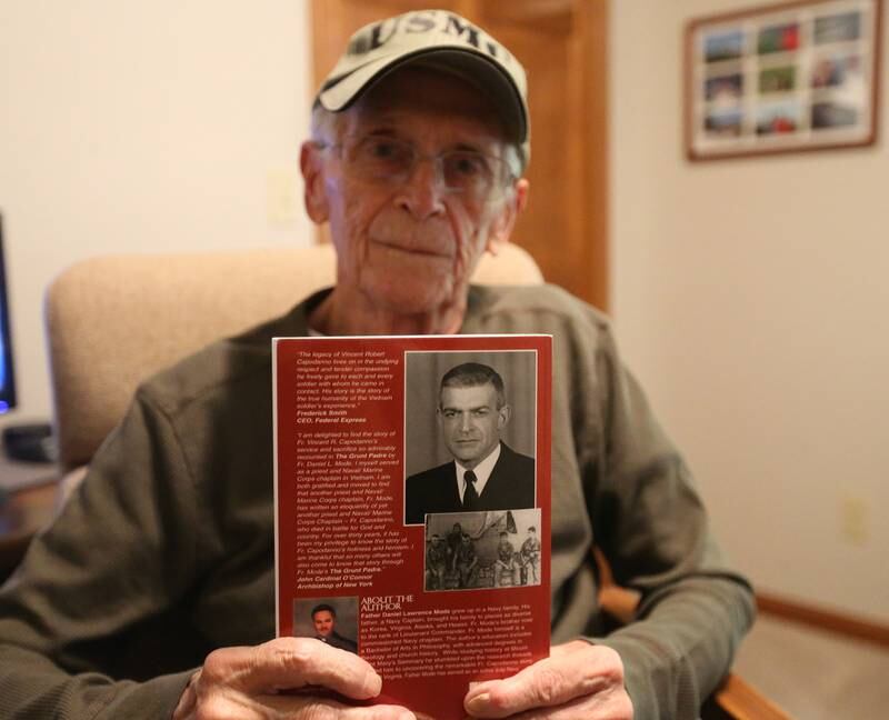 Marine corps Veteran Terry Fischer, holds a book about Vincent R. Capodanno Jr., M.M., a Catholic priest and Maryknoll Missioner killed in action while serving as a Navy chaplain with a Marine Corps infantry unit during the Vietnam War. Fisher served along side Capodanno in the Vietnam War.