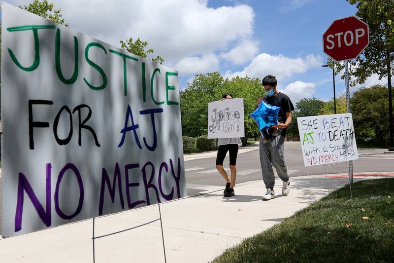 Amy Lagnes of Woodstock, with boyfriend Junior Vazuez and their son Armani Vazquez, walk around the McHenry County Courthouse with signs in support of AJ Freund during the first of a two day sentencing for JoAnn Cunningham, mother of Freund, on Thursday, July 16, 2020.  Cunningham's sentencing will conclude Friday with another rally planned by the same group.