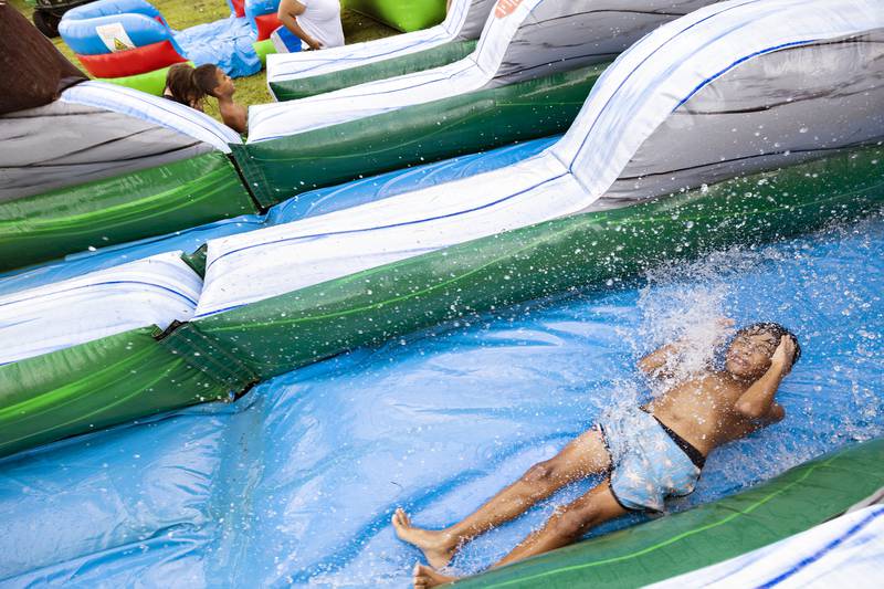 Angel Garcia, 9, takes a run down a water slide Friday, Aug. 1, 2025, in Rock Falls during a day of fun at the Coloma Township Homes.