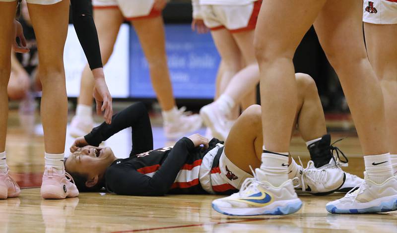 Libertyville'S Sophia Swanson lays on the floor in pain after being found during the IHSA Class 4A Huntley Sectional Championship girls basketball game against Huntley on Thursday, Feb. 27, 2025, at Huntley High School.