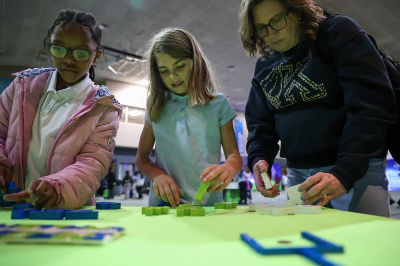 Kankakee third graders Piper Bailey, center, and Nevaeh Evans, left, participate in a challenge with third grade teacher Sara Faulkner during the Impossible Science event at the Kankakee First Church of the Nazarene on May 5, 2026.
