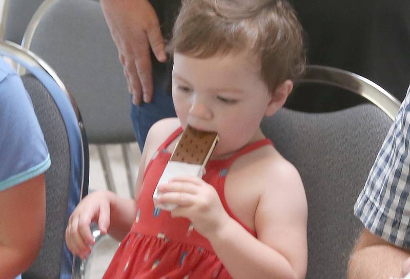 Remi Eichelkraut of Oglesby munches on an  ice cream bar on Wednesday, Aug. 23, 2023 at the Oglesby City Hall. Mayor Jason Curran celebrated his birthday by handing out free ice cream bars and popsicles as a treat to beat the heat.