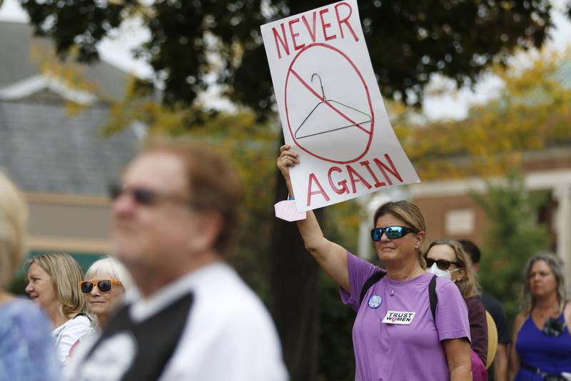 Cathy Meyer, of Genoa City, holds a sign high above the crowd during a rally for abortion rights on the historic Woodstock Square on Saturday, Oct. 2, 2021, in Woodstock.